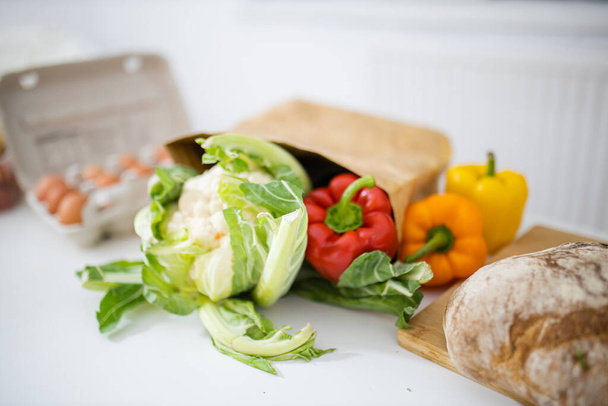 Цвітна капуста і болгарський перець на білому столі поруч з хлібом
 - Фото, зображення