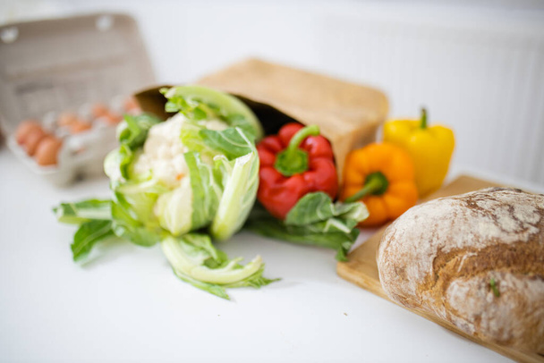 Цвітна капуста і болгарський перець на білому столі поруч з хлібом
 - Фото, зображення