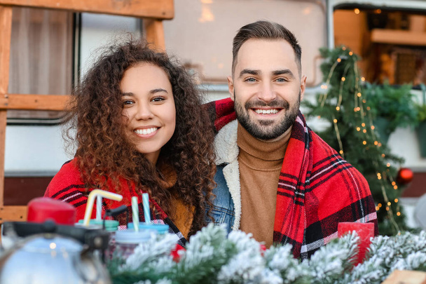 Happy young couple celebrating Christmas outdoors - Фото, изображение