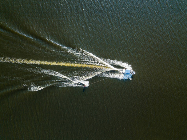 Вид на повітряний безпілотник. Прокинутися серфінгом за човном на річці в сонячний літній день
. - Фото, зображення