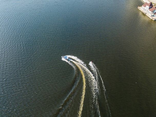 Vista aérea del dron. Despierta surfeando detrás de un barco en el río en un soleado día de verano. - Foto, Imagen