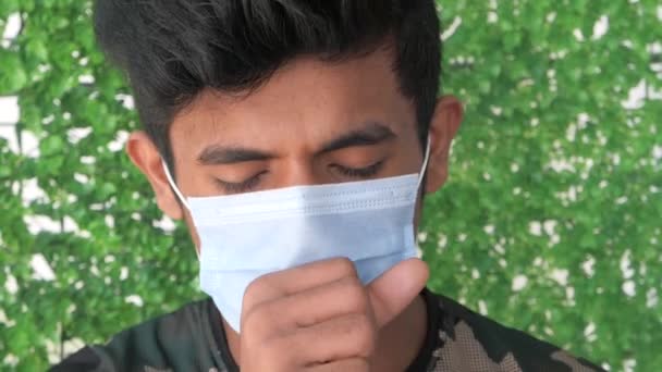  joven hombre en la cara máscara tos y estornudos de cerca  - Metraje, vídeo