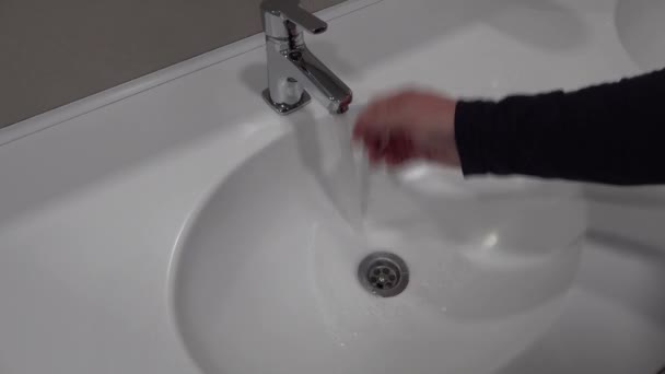hombre se lava las manos en gran fregadero blanco. abre cierra el grifo, toma jabón líquido - Metraje, vídeo