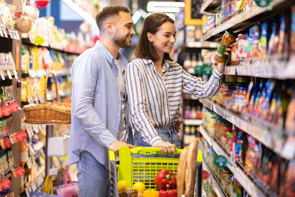 Junges Paar mit Einkaufswagen im Supermarkt - Foto, Bild