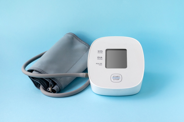 Monitor automático de presión arterial sobre fondo azul. tonómetro electrónico médico - Foto, imagen