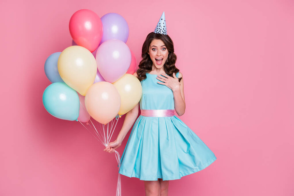 Photo of charming shocked lady festive event birthday party carry many balloons surprise holiday overjoyed wear blue teal short dress cone cap isolated pastel pink color background - Fotografie, Obrázek