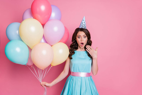 Photo of pretty funny surprised lady celebration event party hold many air balloons birthday overjoyed emotions wear paper cone hat blue teal mini dress skirt isolated pink color background - Fotó, kép