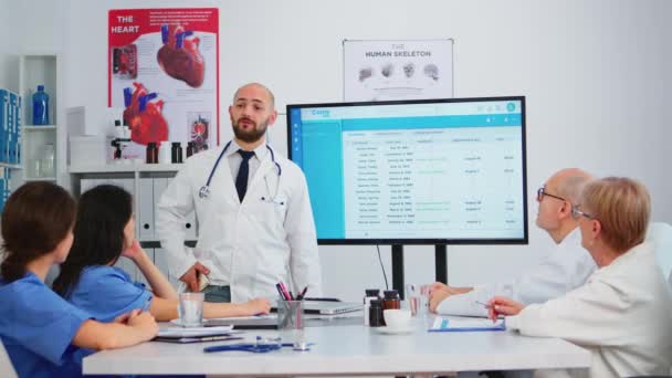 Lekarz specjalista przedstawia kolegom listę oczekujących pacjentów - Materiał filmowy, wideo