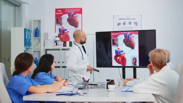 Medico analizzando problemi cardiaci immagine insieme con colleghi cvalified - Filmati, video