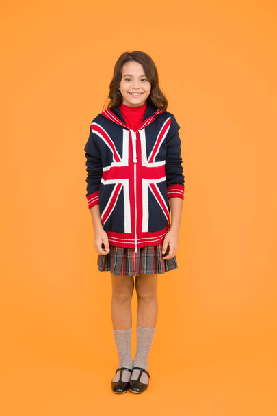 Culture and customs. Small girl school uniform. English student. Education and upbringing. Language school. English kid yellow background. Learn english language. British accent. Great Britain flag - Foto, imagen