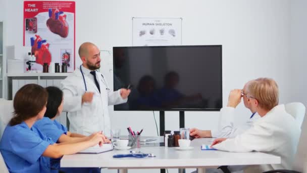 Orvosok csoportja, akik digitális röntgent analizálnak ötletelés közben - Felvétel, videó