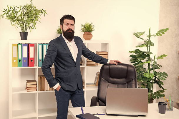Vacant position. Human resource manager in office. Interviewer welcome job candidate. Man having job interview in company HR department. Empty chair. Bearded boss stand in office. Start career here - 写真・画像