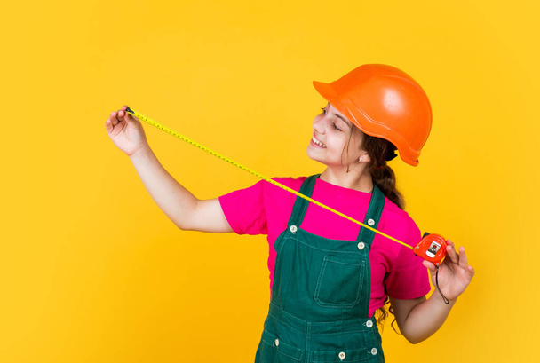 happy kid engineer with tape measure tool in hard hat, measure - Foto, afbeelding