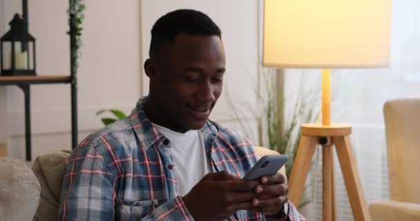 Mann schreibt SMS oder liest lustige Nachricht per Handy - Filmmaterial, Video