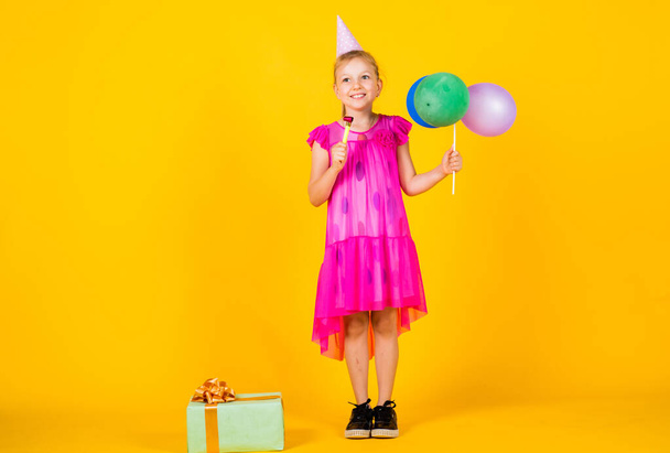 being in good mood. smiling child with party balloons. childhood happiness. pretty teenage girl hold present box. kid celebrate holiday. cheerful birthday girl. best event ever. happy birthday party - Photo, Image