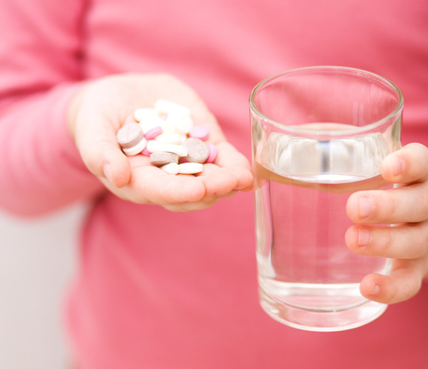 Hand with pills and glass of water - Photo, Image
