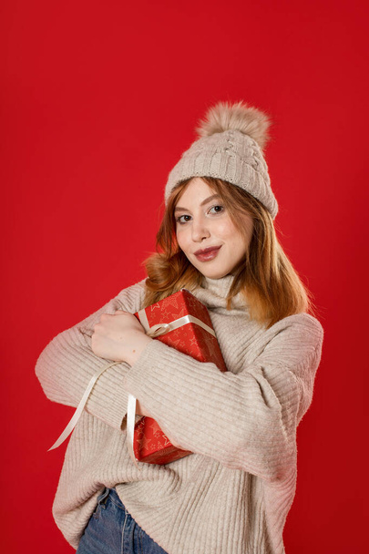 Dreaming winter girl holding christmas present on background - Foto, Bild