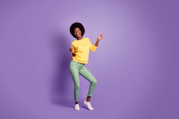 Full length photo of lovely girl look empty space dancing wear yellow pullover isolated violet color background - Foto, immagini