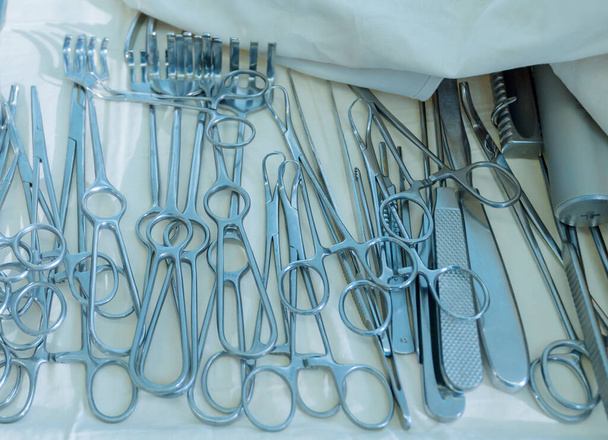 Eine Reihe chirurgischer Instrumente während der Operation. Sie liegen auf einem sterilen Operationstisch. - Foto, Bild