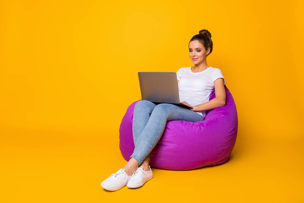 Full size photo of focused smart girl sit purple bag bean work computer read colleagues report document wear style stylish trendy sneakers isolated over bright shine color background - Φωτογραφία, εικόνα
