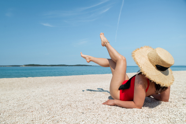 сексуальные женщины в красных купальниках, лежащие на солнечном пляже. копировальное пространство - Фото, изображение