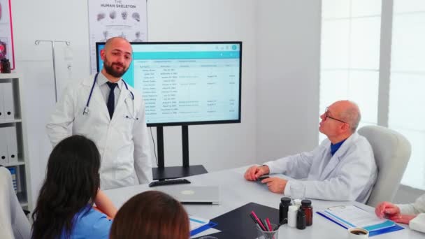 Facharzt präsentiert seinem Team die Liste der erkrankten Patienten - Filmmaterial, Video