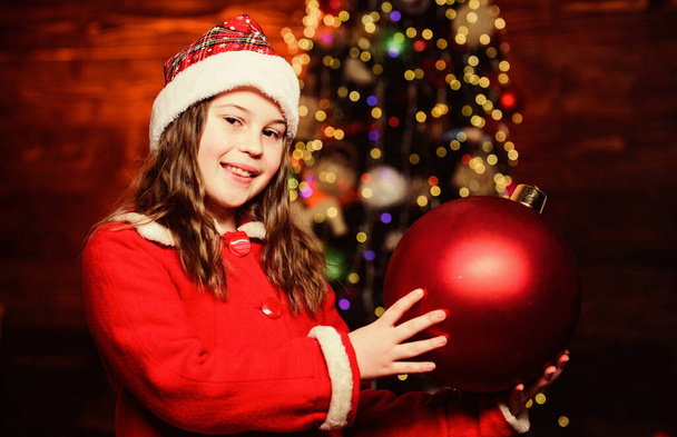 Christmas decorations. Decorate everything around. Sparkling toy. I love decorating christmas tree. Festive atmosphere christmas day. Girl santa claus costume hold big ball christmas tree ornaments - Foto, imagen