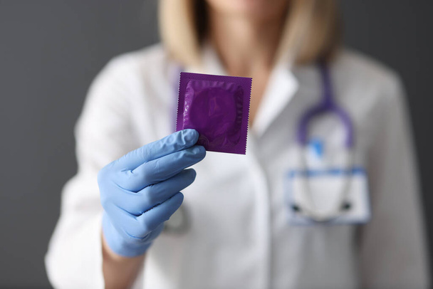 Doctor holds condom in his hand closeup - Photo, Image