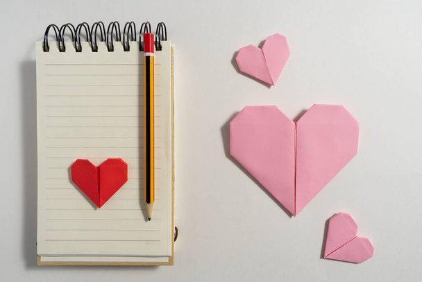 Origami szív készült színes papír gratulálni Valentin-napon a párok a szerelem, a fehér háttér. Szerelmi fogalom - Fotó, kép