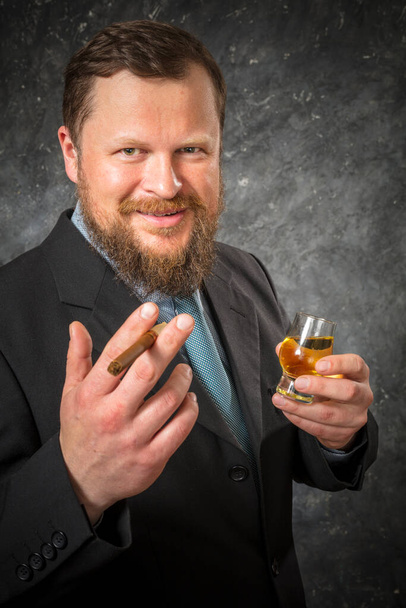 Solid confident bearded man in suit with glass of whisky and cigar - Photo, Image