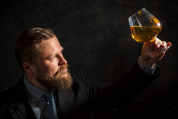 Solid confident bearded man in suit with glass of whisky - Photo, Image