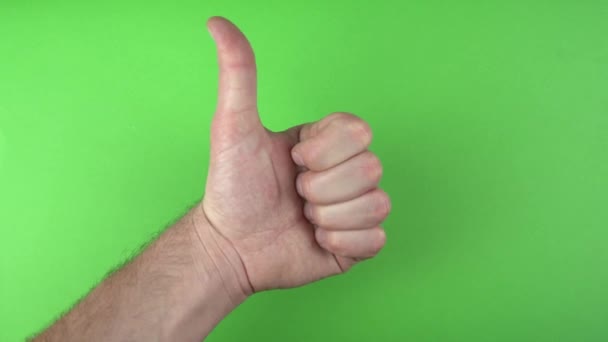 Filmaufnahme einer männlichen Hand, die den Daumen über grünem Hintergrund zeigt - Filmmaterial, Video