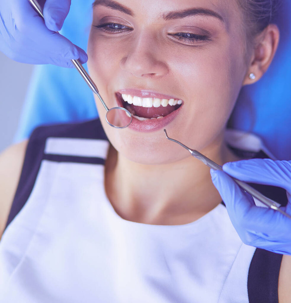 Young Female patient with open mouth examining dental inspection at dentist office. - Photo, image