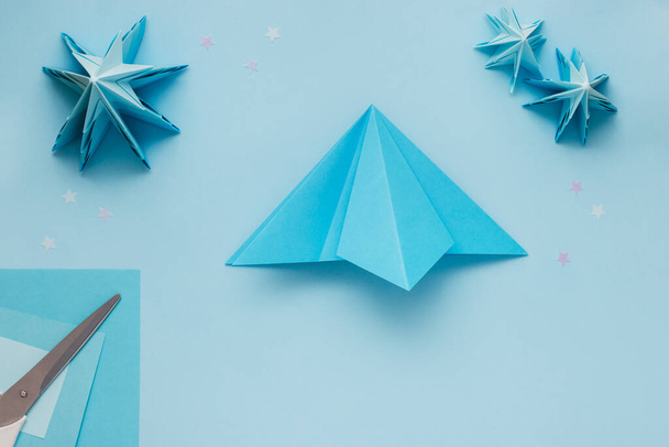 Simple origami 3D Christmas tree made from blue paper. Step by step instruction, step 9 - Zdjęcie, obraz