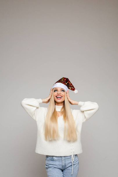 Happy young Caucasian Santa lady in white sweater - Фото, изображение