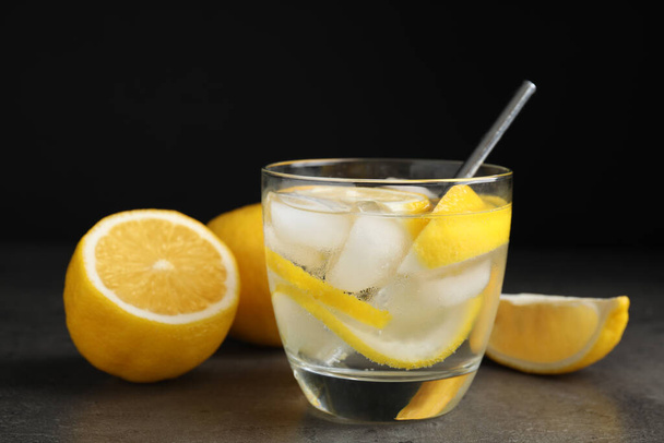 Soda water with lemon slices and ice cubes on grey table - Valokuva, kuva
