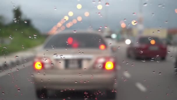 Selectieve focus van de waterdruppel bij de spiegel van de auto. Auto rijdt op straat.. - Video