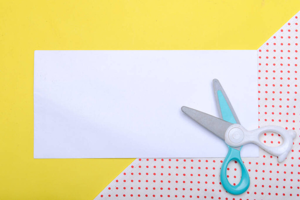 Scissor and empty white paper with a colored background. Empty white paper for copy space - Fotó, kép