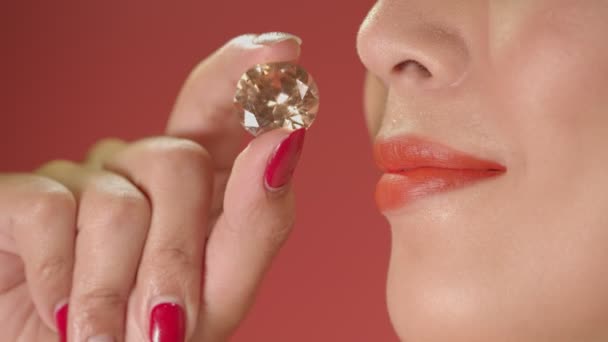 Tartsd a Citrine Yellow gyémántot a rúzs mellettA hölgy mosolya, amikor a Citrine Yellow gyémántot az ajkak közelében tartja - Felvétel, videó