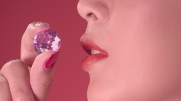 Bekijk de schoonheid van diamanten en kus de Amethist paarse diamantGebruik je vingers om de Amethist paarse diamant vast te houden en kus - Video