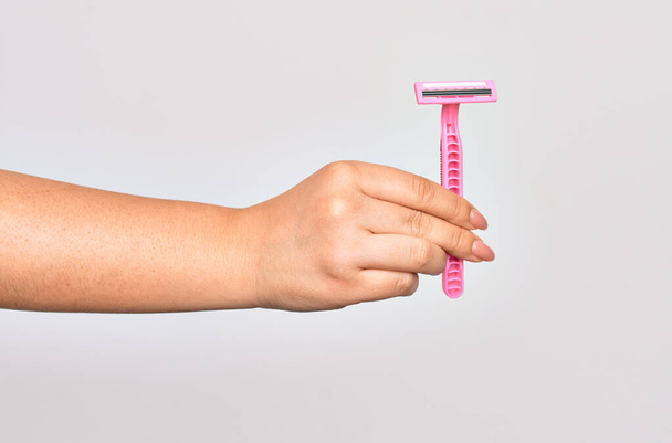Hand of caucasian young woman holding pink razor over isolated white background - Photo, Image