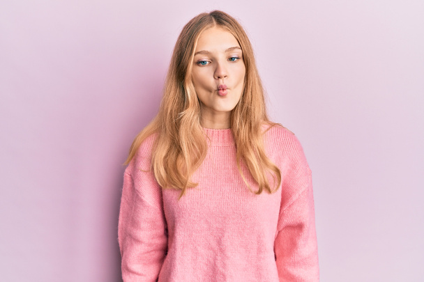 Beautiful young caucasian girl wearing casual clothes making fish face with lips, crazy and comical gesture. funny expression.  - Foto, Imagen