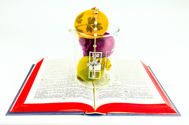 Ovos de Páscoa em vidro de laboratório com rosário em uma Bíblia sagrada
 - Foto, Imagem