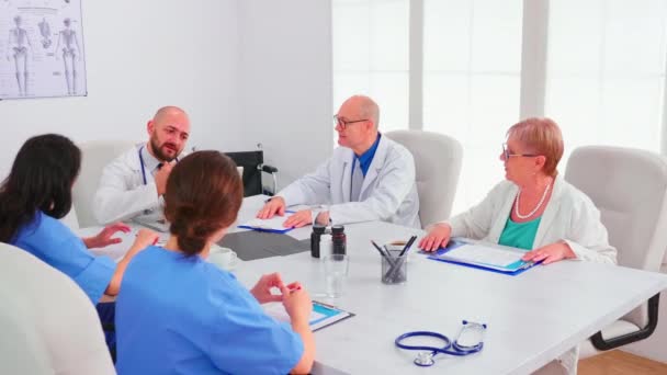 Médico especialista informando a su equipo médico en la sala de conferencias del hospital - Metraje, vídeo