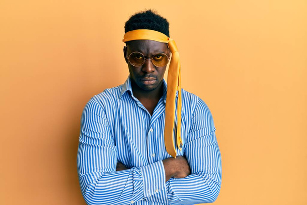 Handsome black man drunk wearing tie over head and sunglasses skeptic and nervous, disapproving expression on face with crossed arms. negative person.  - Photo, Image