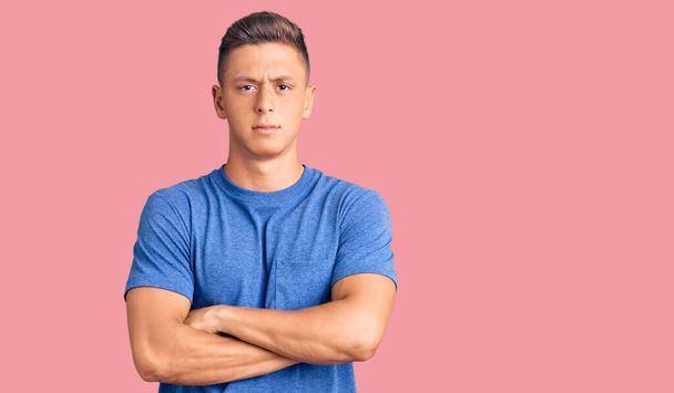 Young handsome hispanic man wearing casual clothes skeptic and nervous, disapproving expression on face with crossed arms. negative person.  - Photo, Image