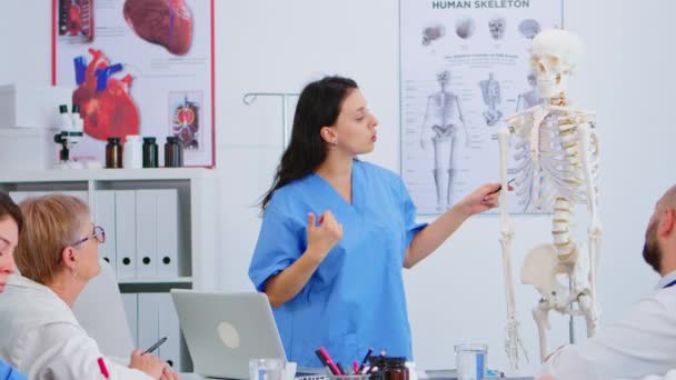 Medico che descrive la disposizione della colonna vertebrale umana di fronte ai colleghi - Filmati, video