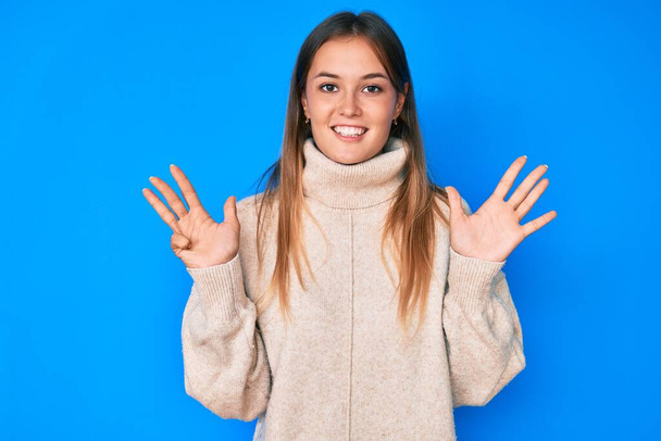 Piękna biała kobieta nosi wełniany zimowy sweter pokazując i wskazując palcami numer dziewięć uśmiechając się pewny siebie i szczęśliwy.  - Zdjęcie, obraz