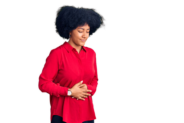 Giovane ragazza afroamericana indossa abiti casual con mano sullo stomaco perché indigestione, malattia dolorosa sensazione di malessere. concetto di dolore.  - Foto, immagini