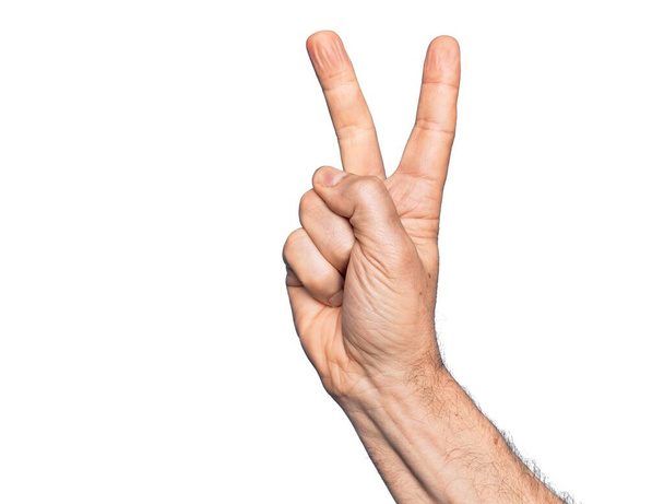 Mano di uomo caucasico di mezza età su sfondo bianco isolato conteggio numero 2 mostrando due dita, gesticolando vittoria e simbolo del vincitore - Foto, immagini
